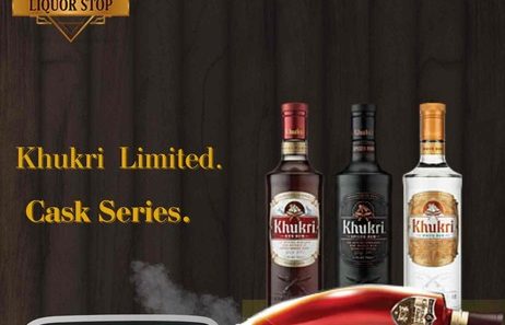 A premium banner for Khukri Limited Cask Series rum featuring three bottles—Himalayan Gold, Dark Rum, and White Rum—on a dark wooden table against a background of aged oak barrels.
